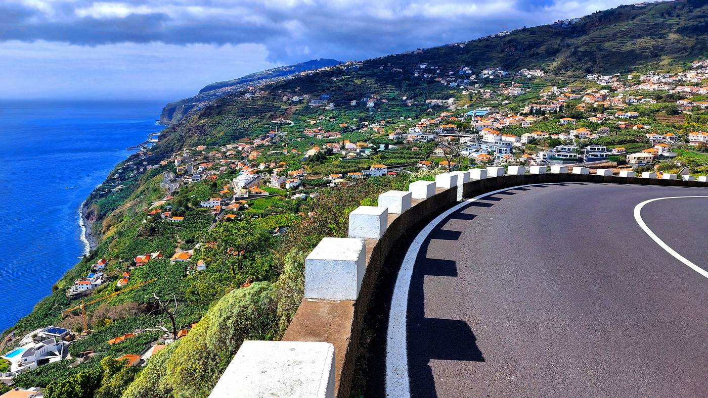 A bend in the coast road above the terraces of Arco da Calheta, the Atlantic below