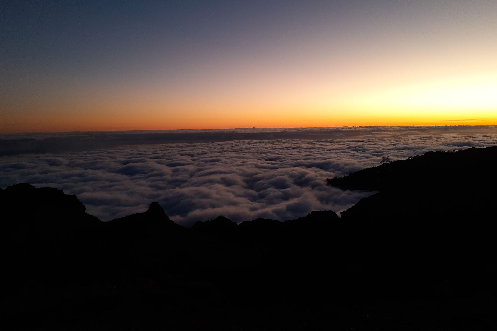 The sky glowing orange after sunset above a sea of cloud, seen from the Paul da Serra plateau