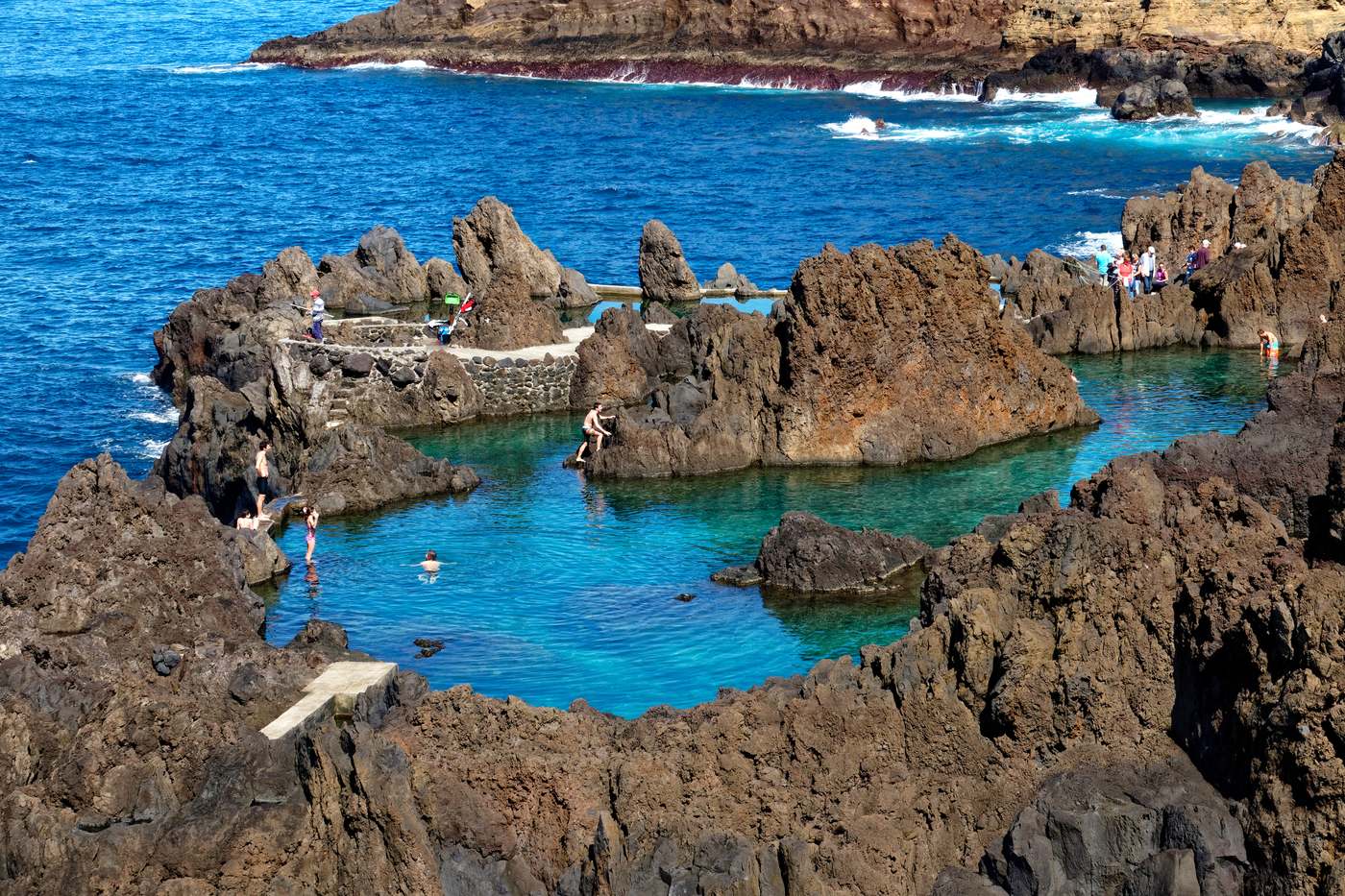 A turquoise seawater pool between black lava rocks at Porto Moniz
